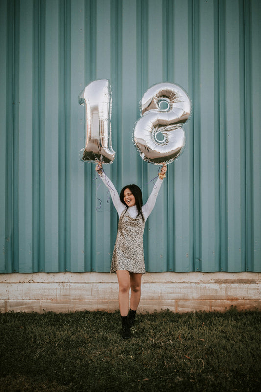 Jeune femme tenant des ballons, cadeau anniversaire 18 ans et passage à la majorité
