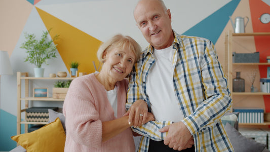 Couple mature souriant côte à côte, un mari attentionné offrant un cadeau à sa femme